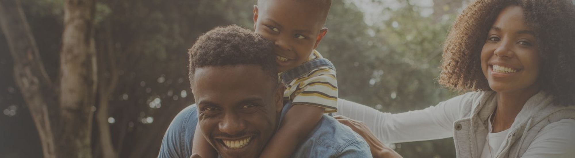 Smiling couple outside with toddler